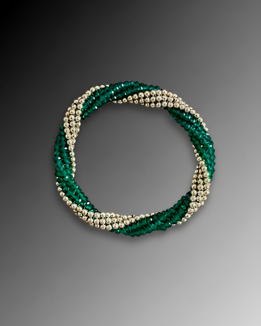 Green and gold beaded bracelet on a gray background